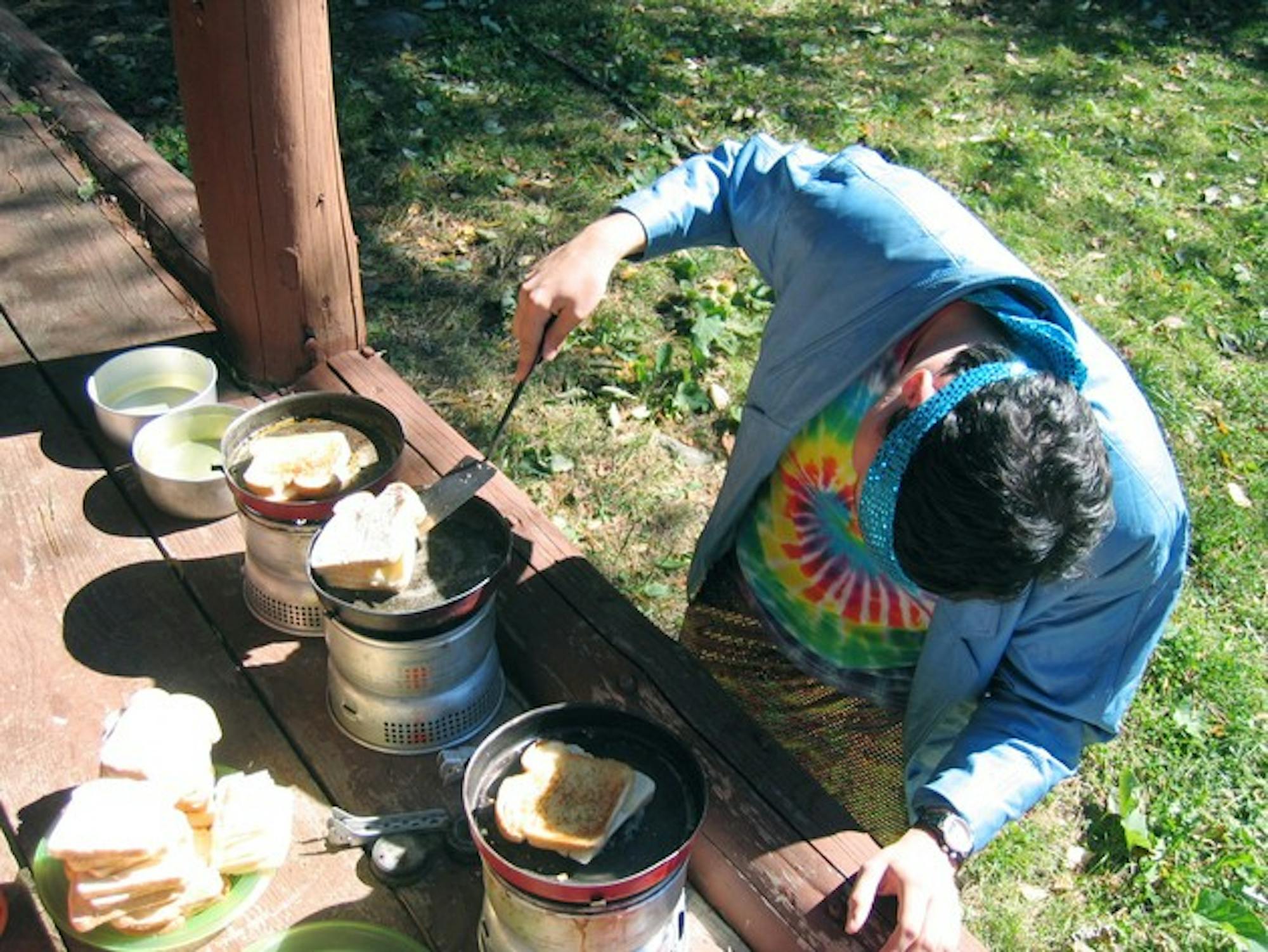 Support staff member makes grilled cheese sandwiches for '50' hikers in anticipation of the Darmouth Outing Club excursion this weekend.