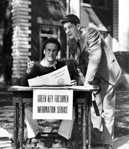Wearing the traditional beanies, freshmen volunteer at the information desk for returning alumni during 1940's Green Key weekend.