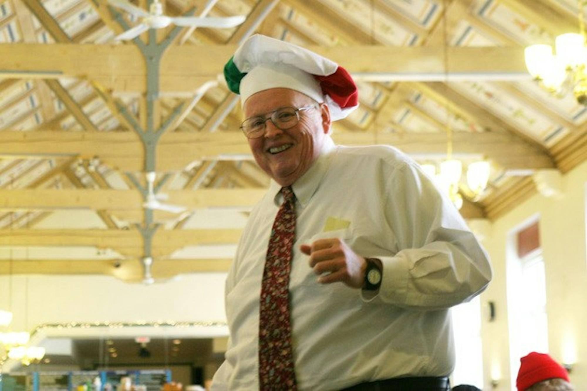 Larry James shows off a chef's hat bearing the colors of the Italian national flag in Food Court during one of the many themed dinner events he hosted over the course of his seven years at the College.
