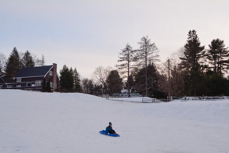 A student takes a study break and goes&nbsp;sledding on the golf course.