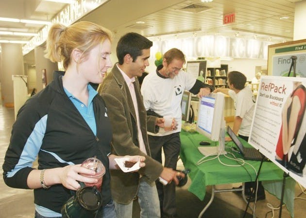 Norah Comstock '08 and Santi Vallinas '07 attend booths at the 