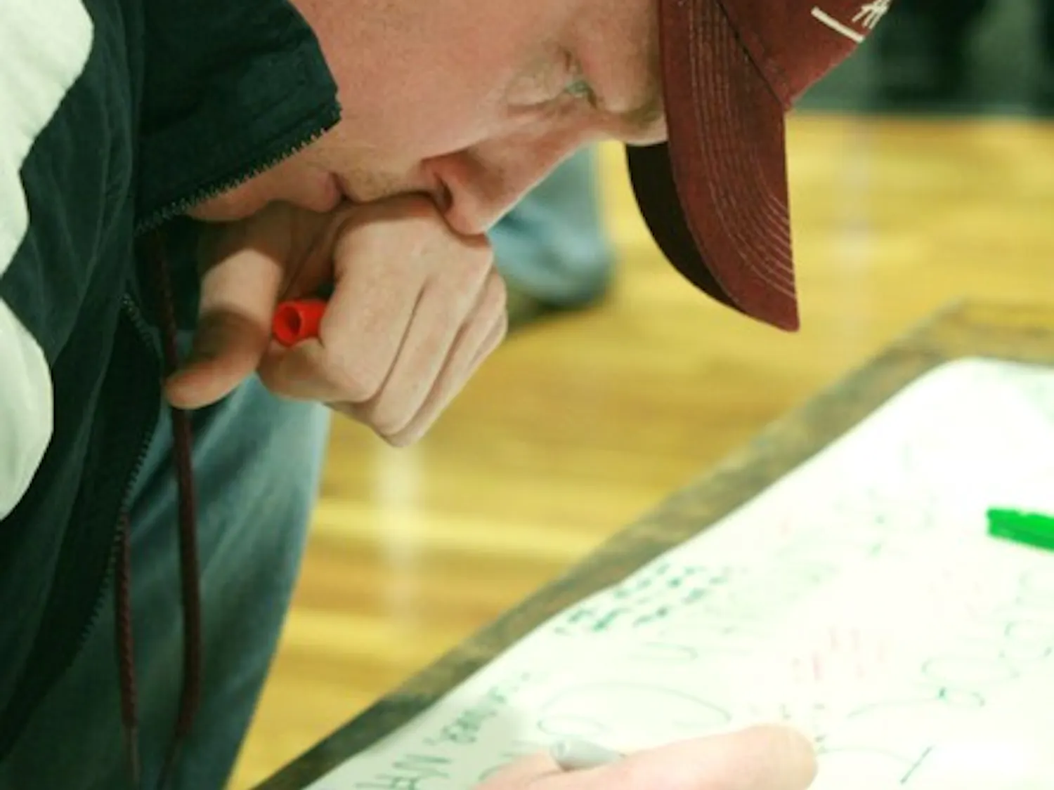 A participant in Monday night's vigil ceremony, sporting a Virginia Tech hat, signs a giant card in Collis Cafe. It will be sent to the university Wednesday.