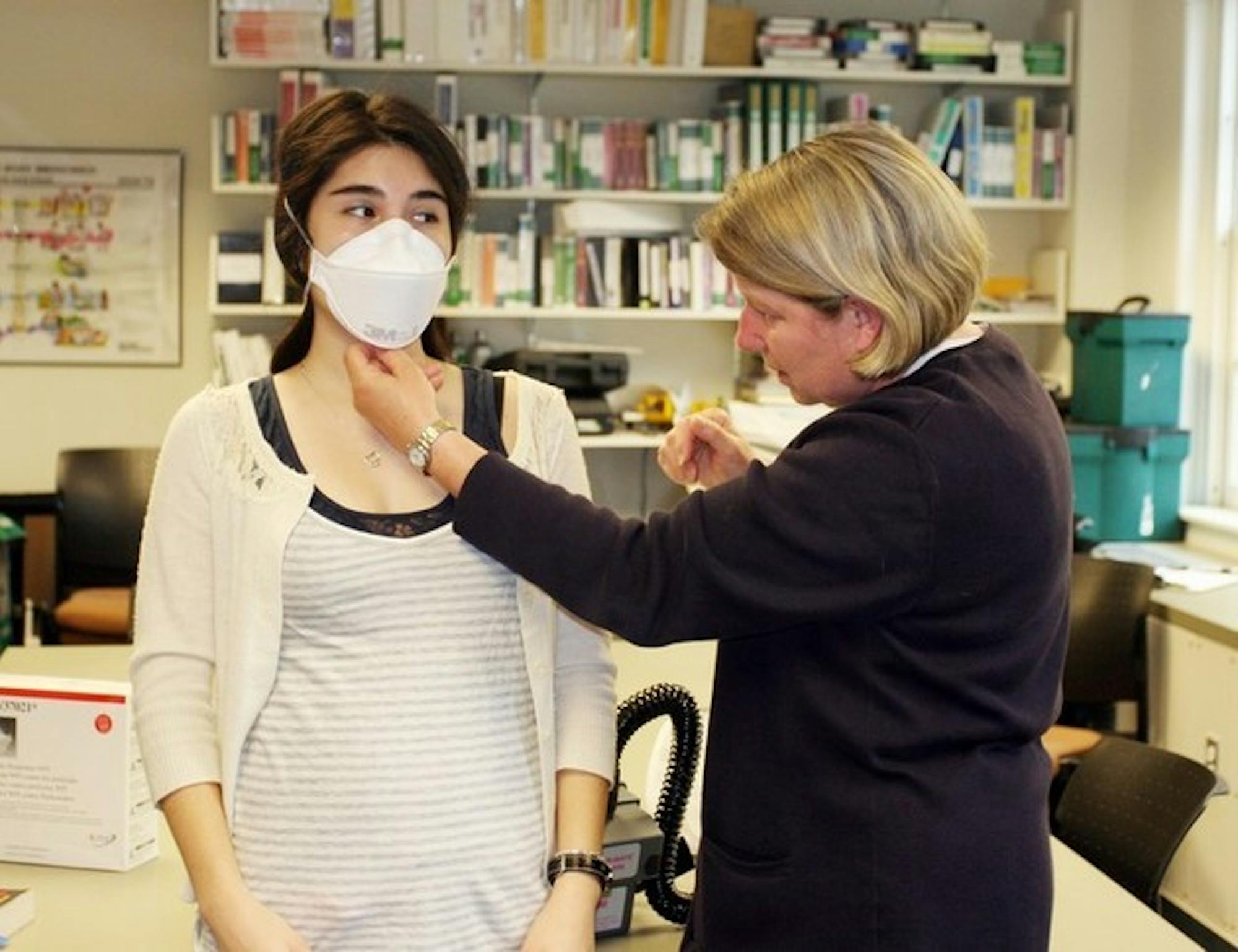 Staff writer Christine Paquin '09 tries on a mask with Brenda Freeland.