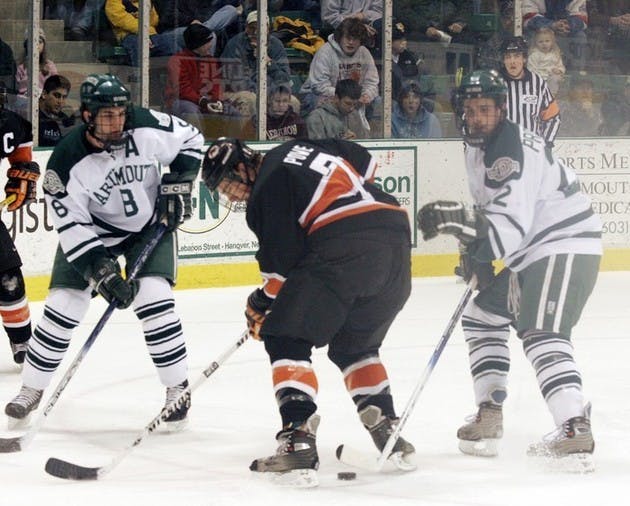 Garret Overlock '06 (pictured left) and Rob Pritchard '09 (right) work together to control a loose puck. The Big Green hopes that next year its freshmen will mesh with the team's veterans as well as they did in 2005-06.