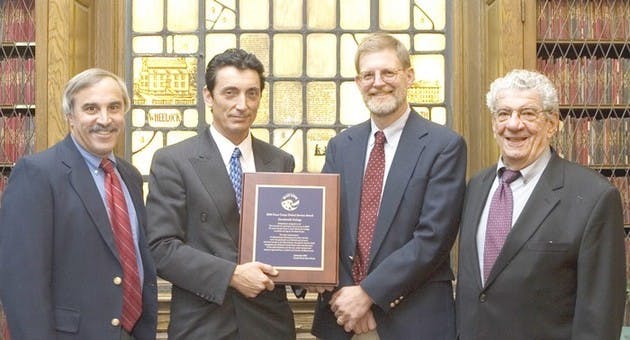 Peace Corps representative James Arena-DeRosa (second from left) presents the 200 Global Service Award to Career Services Director Skip Sturman, Acting Dean of the College Dan Nelson and professor John Rassias Wednesday.