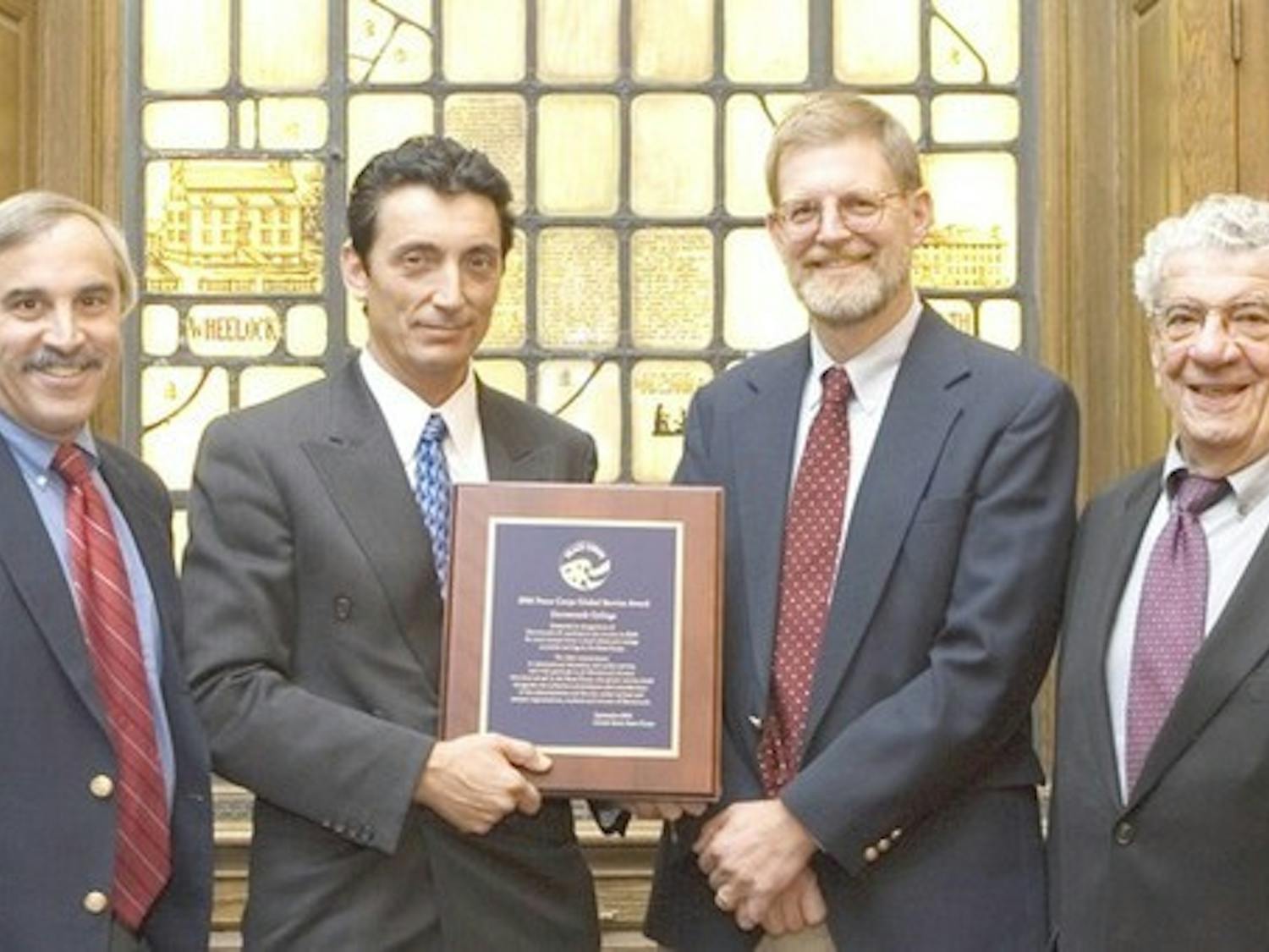 Peace Corps representative James Arena-DeRosa (second from left) presents the 200 Global Service Award to Career Services Director Skip Sturman, Acting Dean of the College Dan Nelson and professor John Rassias Wednesday.