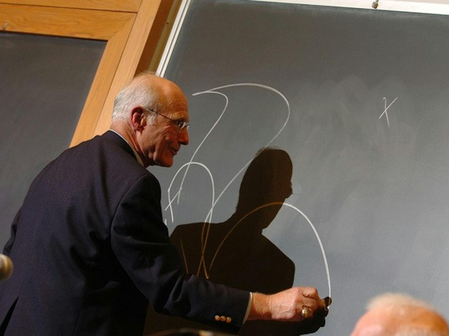 Dartmouth-Hitchcock Medical Center pediatrician Alan Rozycki '61 illustrates his point on a Rockefeller Center blackboard during his discussion of ethics at a panel sponsored by Undergraduate Judicial Affairs.