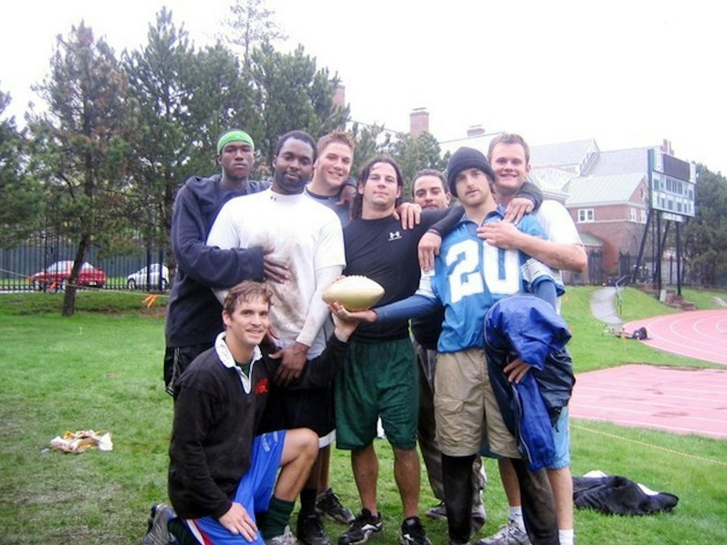 The Turdsquashers display the golden football in the rain after rolling over Chi Gam 13-0 in the fraternity league championship game.
