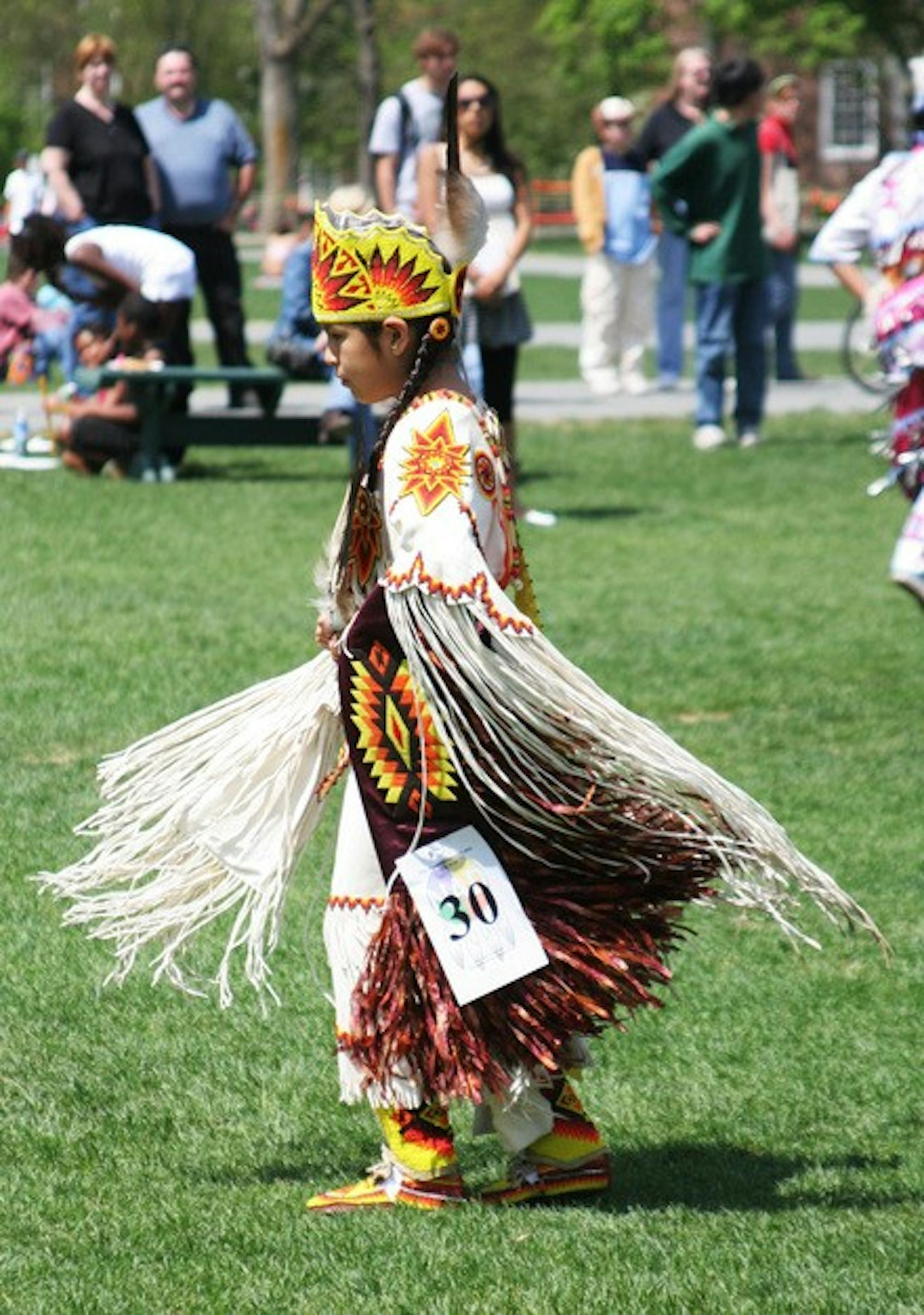A girl in ceremonial garb marches on the Green in the center of this weekend's well-attended Pow-wow, which attracted visitors from far and wide.