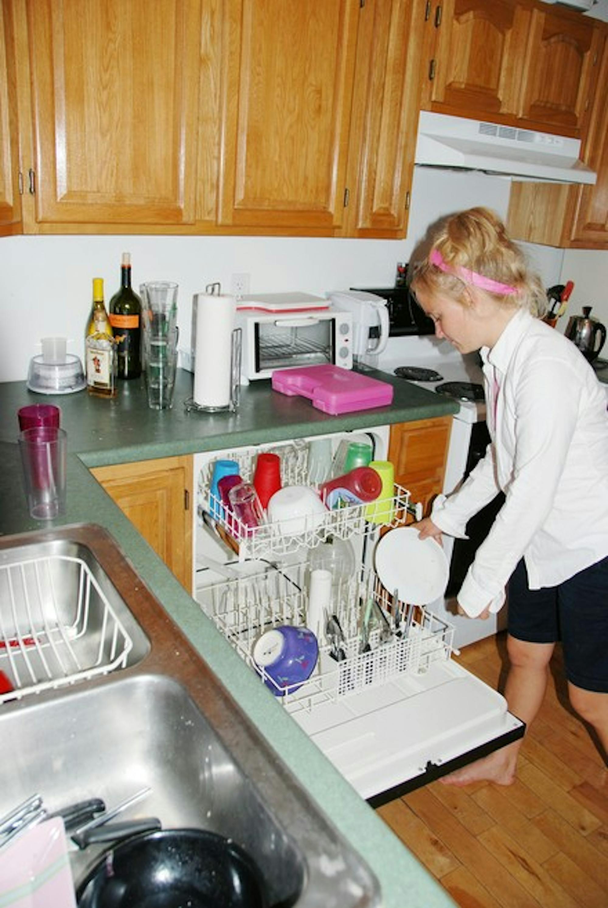 Betsy Bryant \'08 unloads the dishwasher at her off-campus, senior-year apartment.