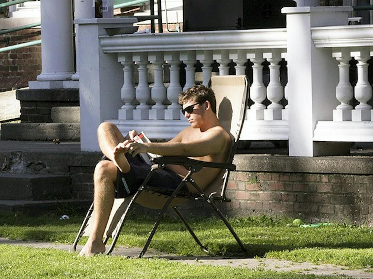 STUDYING, STUDYING YEAH: A sophomore enjoys the summer sun outside of Alpha Delta fraternity doing some reading.