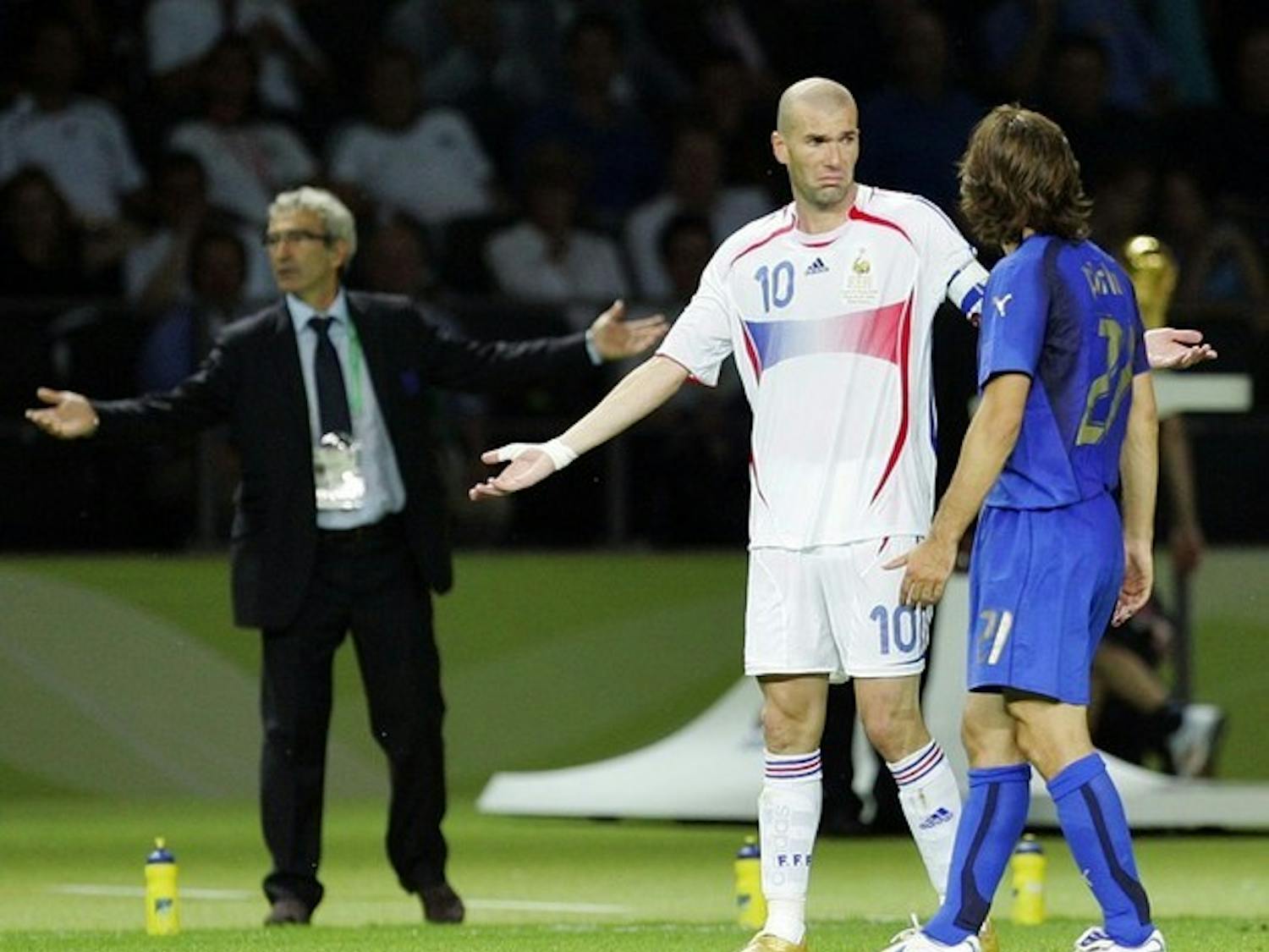 Zidane feigns innocence after his attack on Materazzi while the refereeing team attempts to sort out exactly what had just transpired.Zidane feigns innocence after his attack on Materazzi while the refereeing team attempts to sort out exactly what had just transpired.