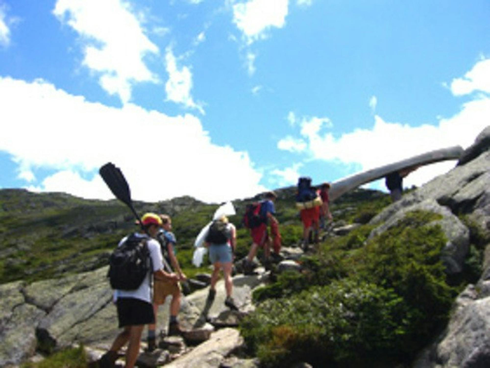Undergraduates hike with a 40-pound aluminum canoe and a hand-made banner to the peak of Mount Washington.