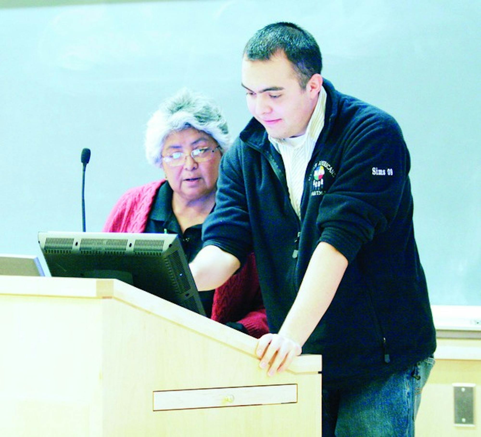 Aaron Sims \'09 assists his mother, University of New Mexico professor Christine Sims, during her Tuesday speech at First Nations week.