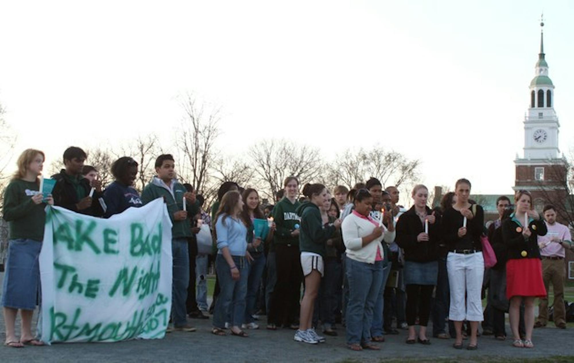 Students participating in 'Take Back the Night' gather in the center of the Green on Wednesday evening to rally against sexual assault.