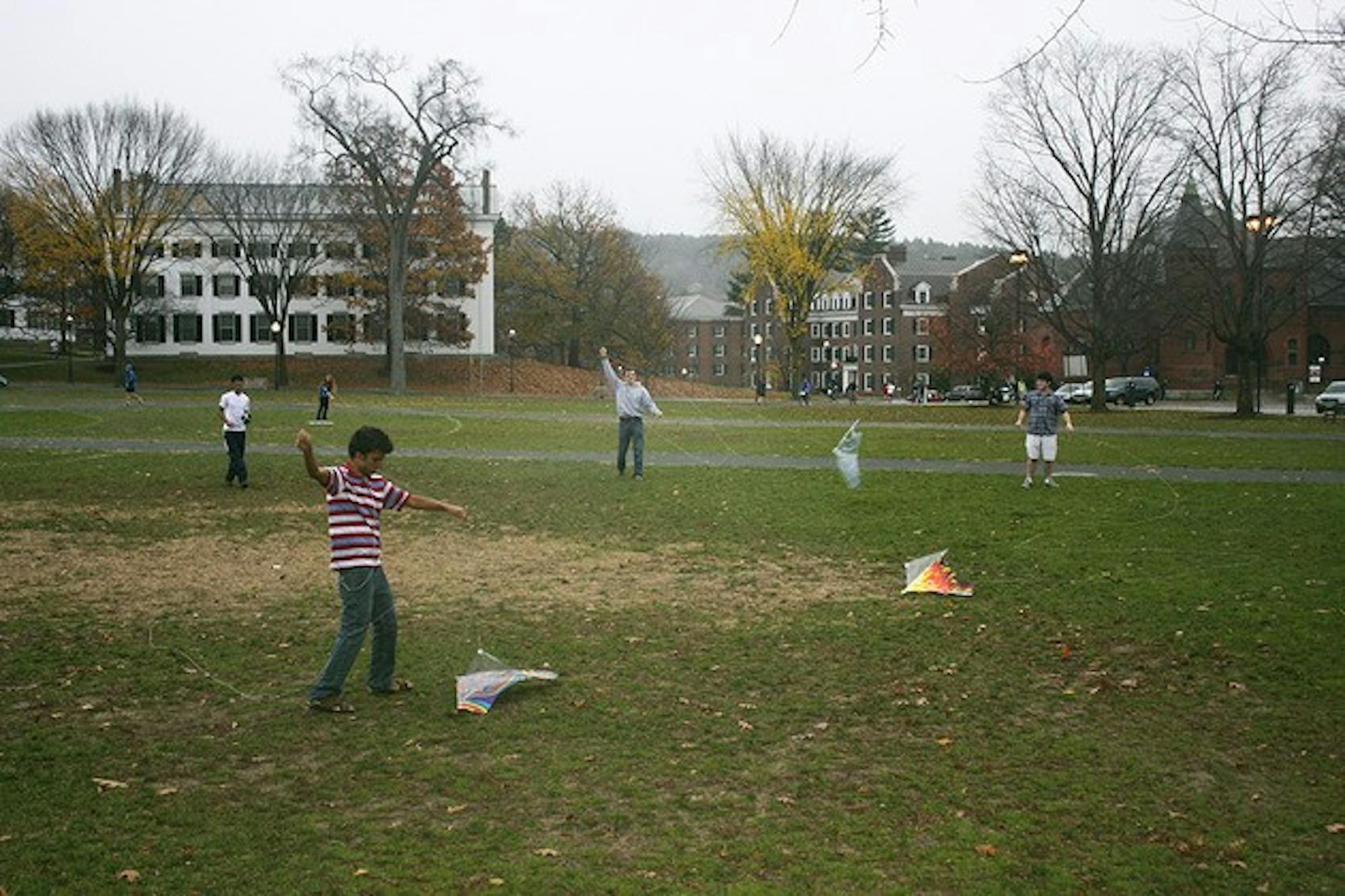 Students unsuccessfully try to fly kites on the Green as winds pick up around 4 p.m. on Monday.