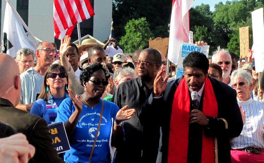 Rev. William Barber, pictured holding microphone, is president of the N.C. NCAA and has been a leader in protests against new voting regulations that some say are hurting minorities.