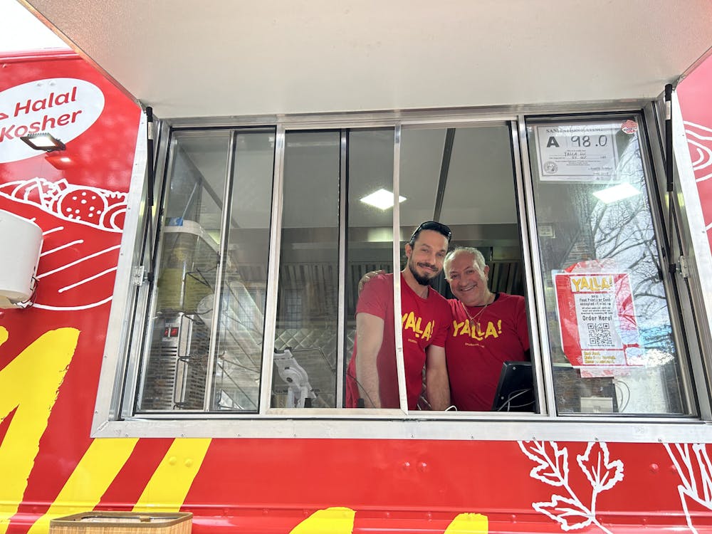 <p>From left: Daniel Alexander, one of Yalla's operators, and Ami Biton, a Yalla cook, at the truck Monday afternoon. &nbsp;</p>