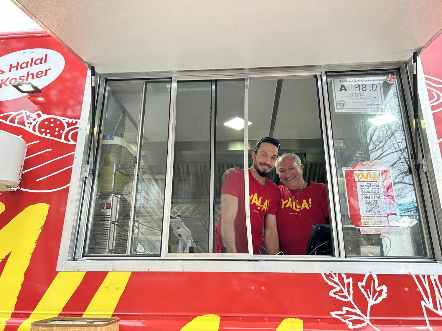 From left: Daniel Alexander, one of Yalla's operators, and Ami Biton, a Yalla cook, at the truck Monday afternoon. &nbsp;