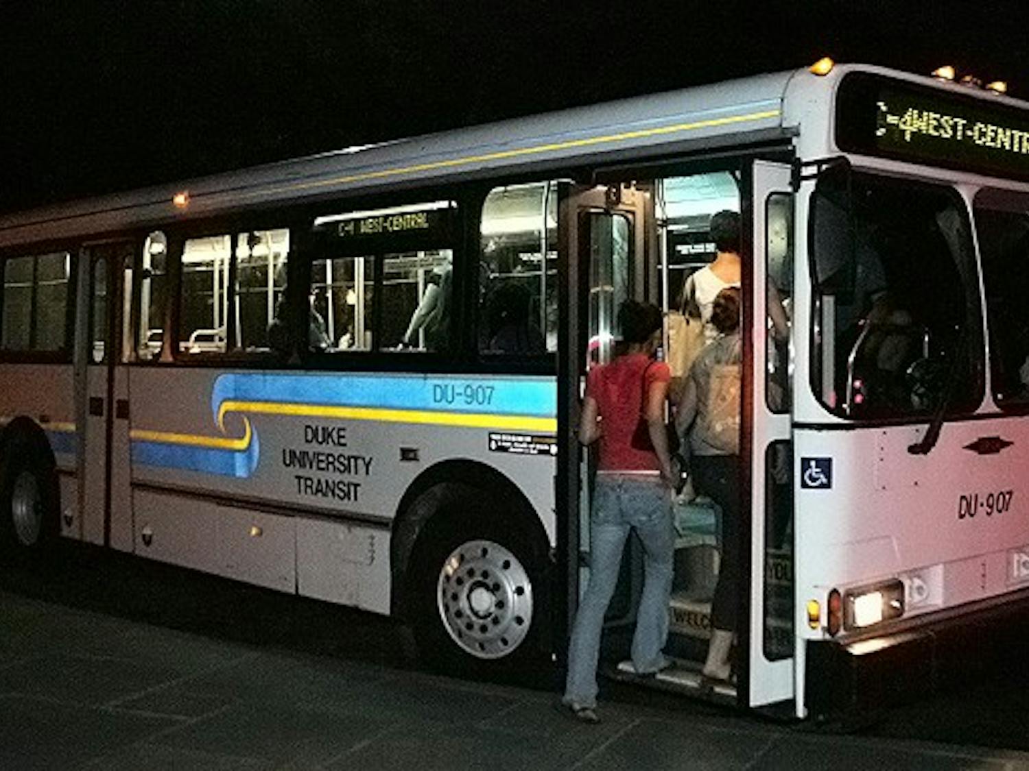 Students board a bus after waiting at the West Campus bus stop.  A new initiative, which is expected to be implemented this Fall, will use prepaid Motorola mobile phones to track all campus buses.