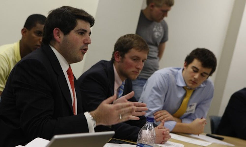 Interfraternity Council President Eric Kaufman (left) and other fraternity members voice their concerns about the RGAC process Wednesday night in front of administrators and representatives from RGAC and Campus Council.