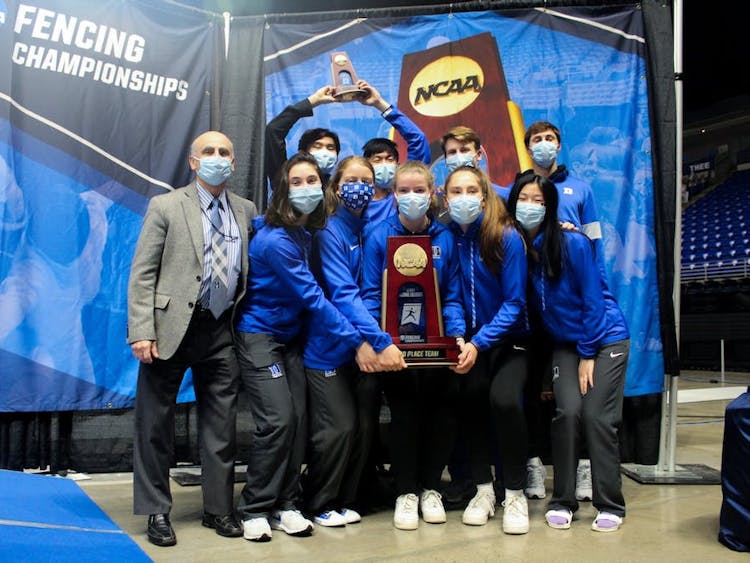 Head coach Alex Beguinet (left) poses with his team after finishing third in the 2021 NCAA Championships.