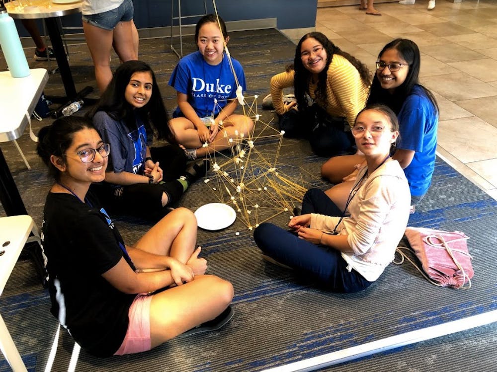 Members of FEMMES+ lead students in engaging, hands-on STEM activities. Photo taken pre-COVID. Photo courtesy of Melanie Pierce.