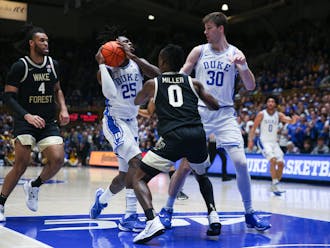 Mark Mitchell (left) drives to the rim supported by Kyle Filipowski (right) against Wake Forest.