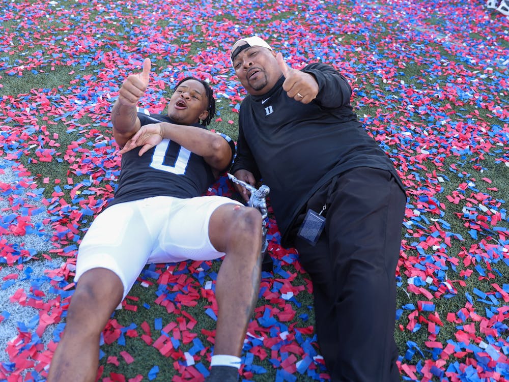 Chandler Rivers (left) and Trooper Taylor lie in the confetti after winning the Birmingham Bowl.