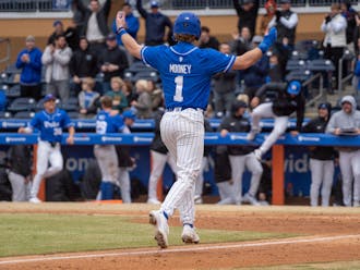 Duke sophomore Alex Mooney motions to the dugout as he approaches home plate against St. Joseph's.