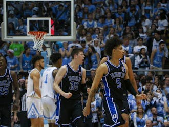 Mark Mitchell (25), Kyle Filipowski (30) and Tyrese Proctor (5) celebrate during Duke's March 4 win against North Carolina.