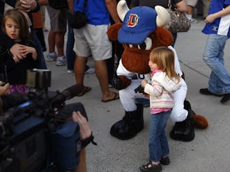 The Durham Bull’s mascot poses with a fan during the team’s celebration of its recent national championship Wednesday night. The event featured free hot dogs and games of catch inside the Durham Bulls Athletic Park.