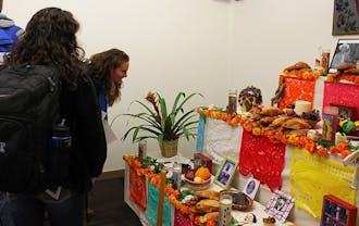 Students look at a food display at a Day of the Dead celebration photo exhibit in the Jameson Gallery. The exhibit will run through Nov. 6.