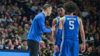 Head coach Jon Scheyer meets with guards Caleb Foster and Tyrese Proctor in Duke's game against Wake Forest.