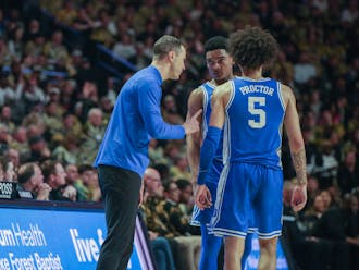 Head coach Jon Scheyer meets with guards Caleb Foster and Tyrese Proctor in Duke's game against Wake Forest.