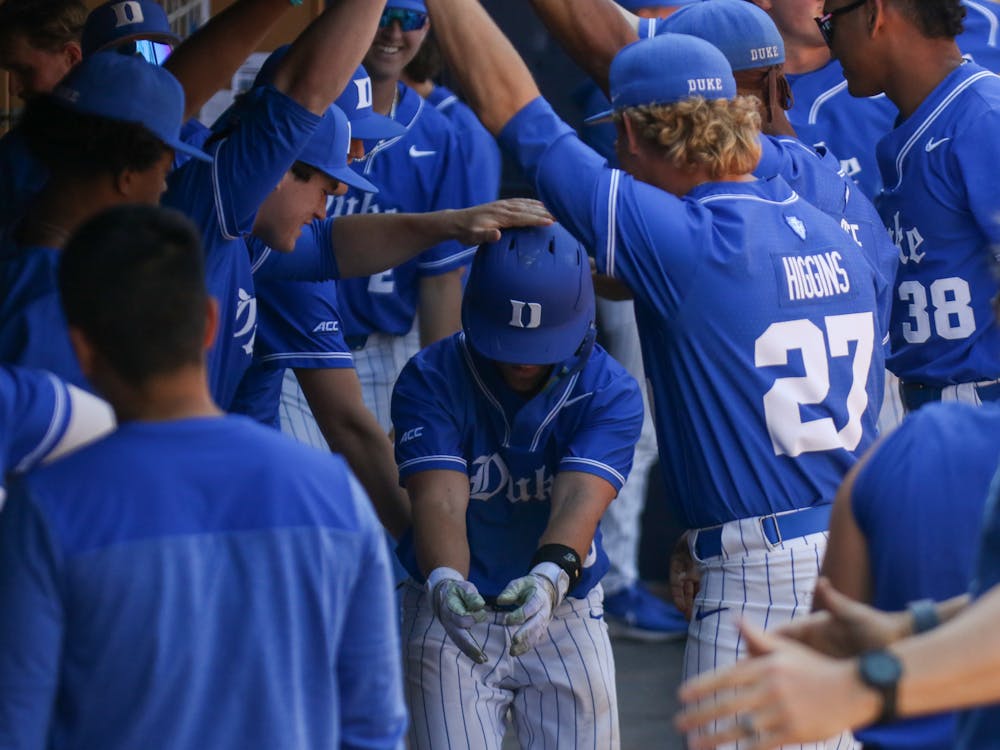 Sophomore Alex Mooney celebrates in the dugout after scoring the go-ahead run in Duke's 4-3 win against Louisville.&nbsp;