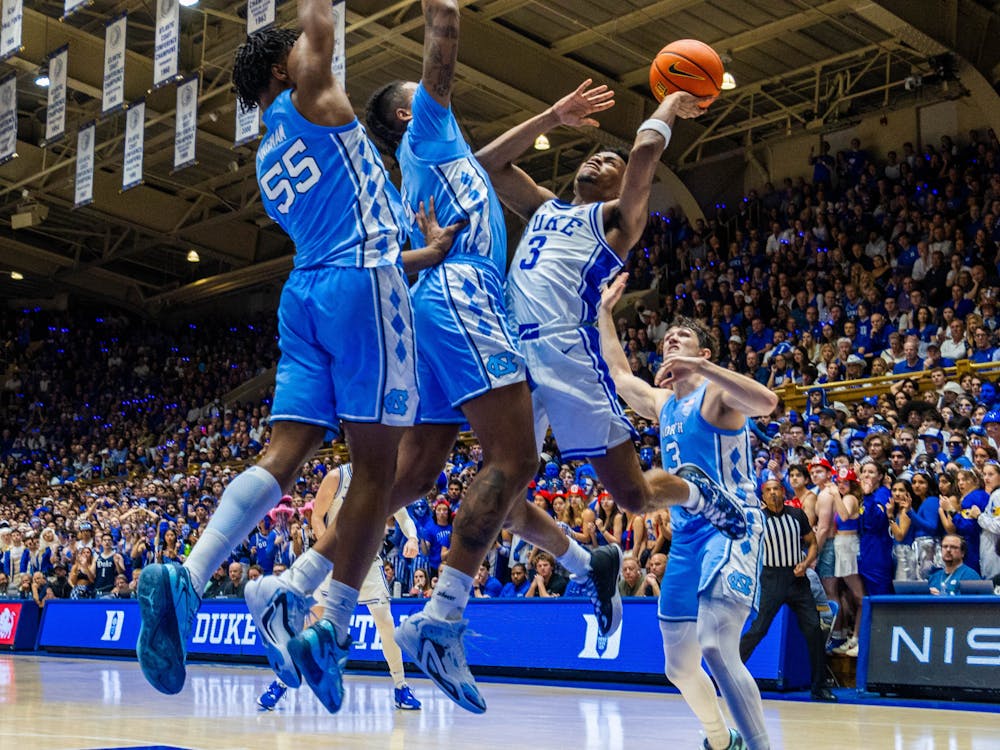 Jeremy Roach goes up for a shot against Armando Bacot and Harrison Ingram in Duke's home loss to North Carolina.