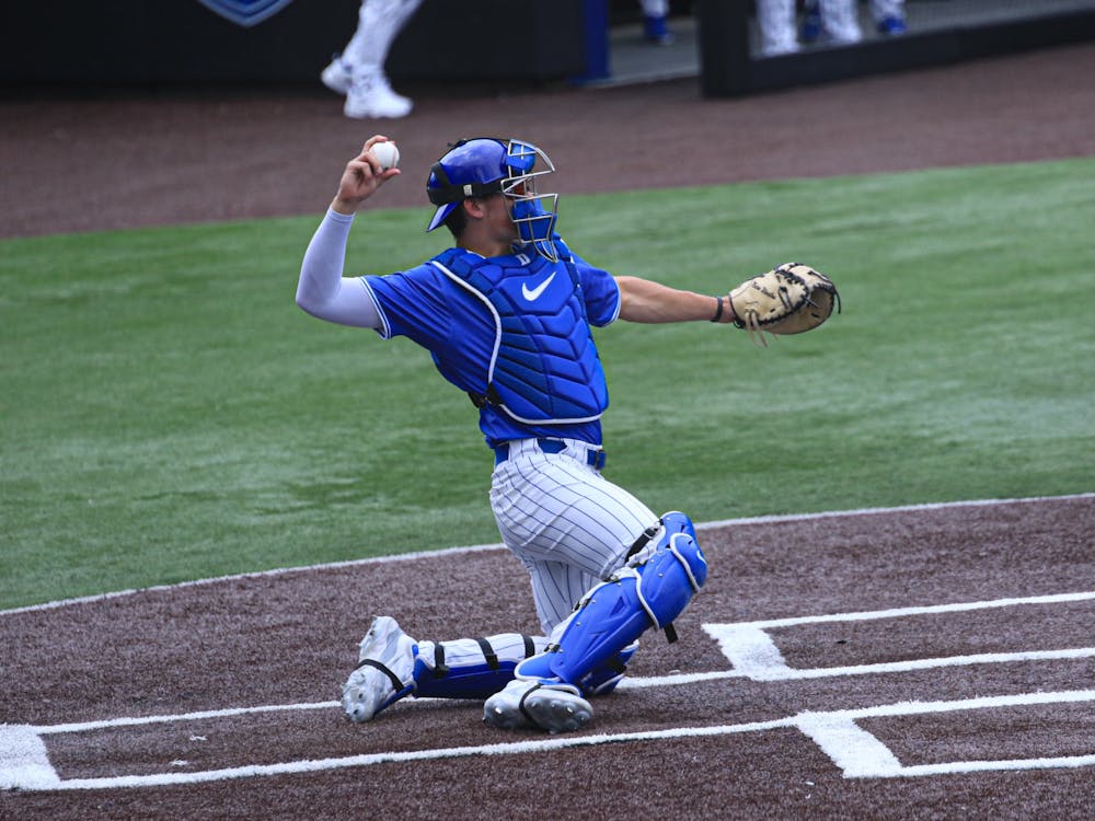 Senior catcher Alex Stone throws the ball back to the pitcher.