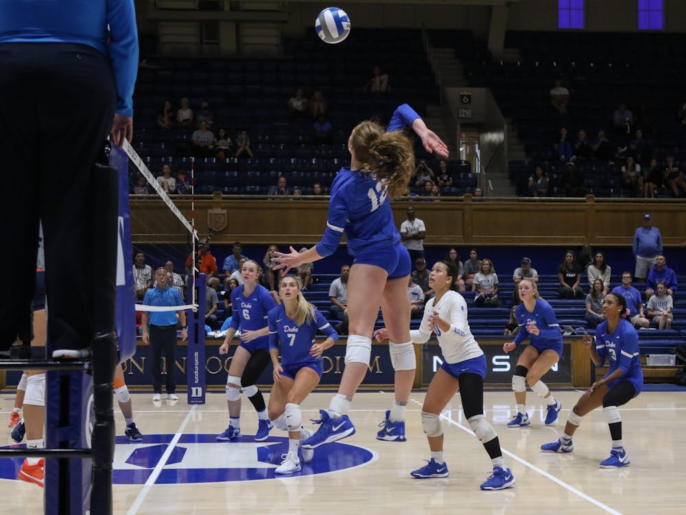 Freshman Avery Hamlin leaps above the net for the ball.