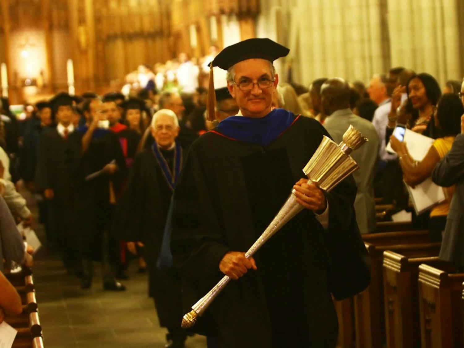Joshua Socolar, chair of Academic Council, walks away from the alter after the Founders' Day convocation.