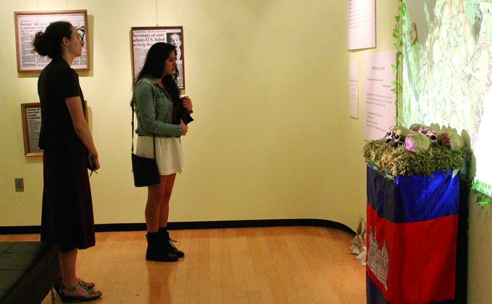 Visitors observe a multimedia exhibit representing photos of moments of genocide throughout the world during Genocide Remembrance Week.