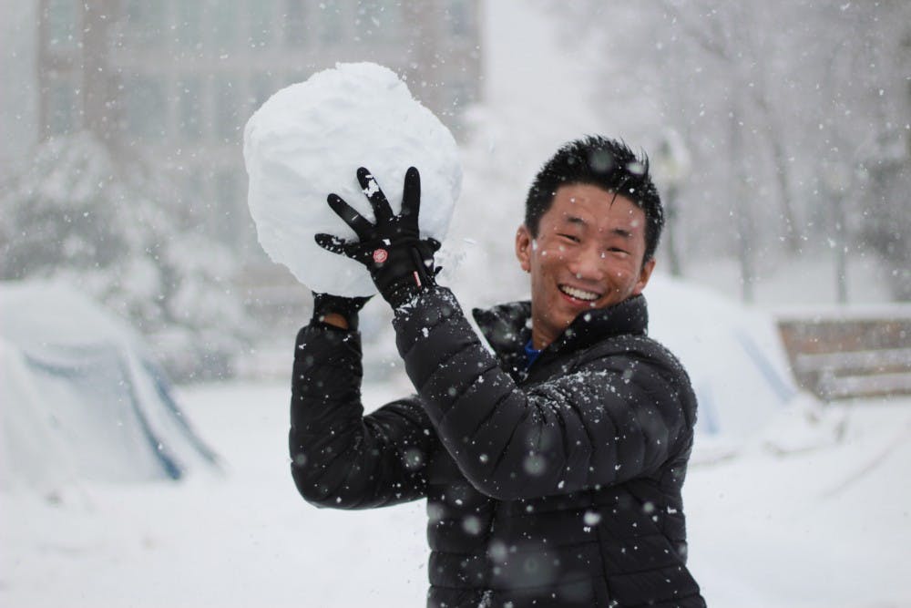 One student gets ready to throw a large snowball.