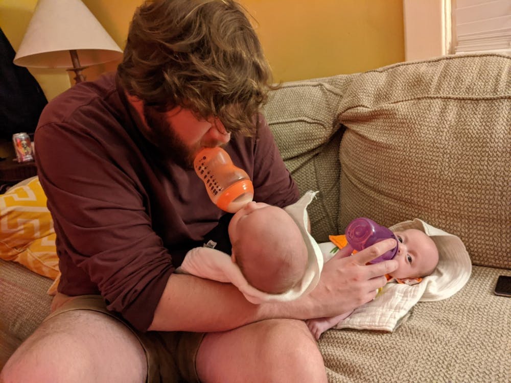 <p>Brian Fitzpatrick feeds his newborn twins.</p>
