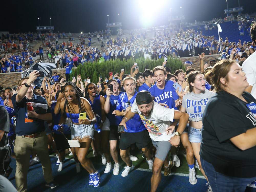 Students storm the field after Duke's surprise win against Clemson.