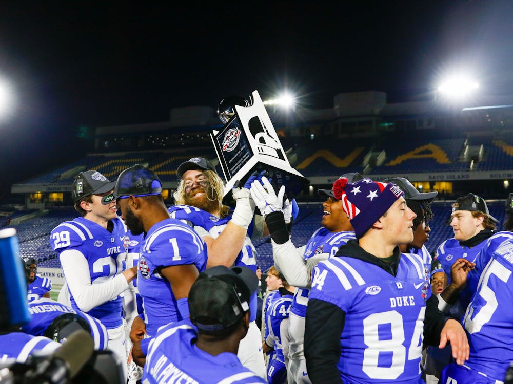 Duke players take turns with the Military Bowl trophy after the win.