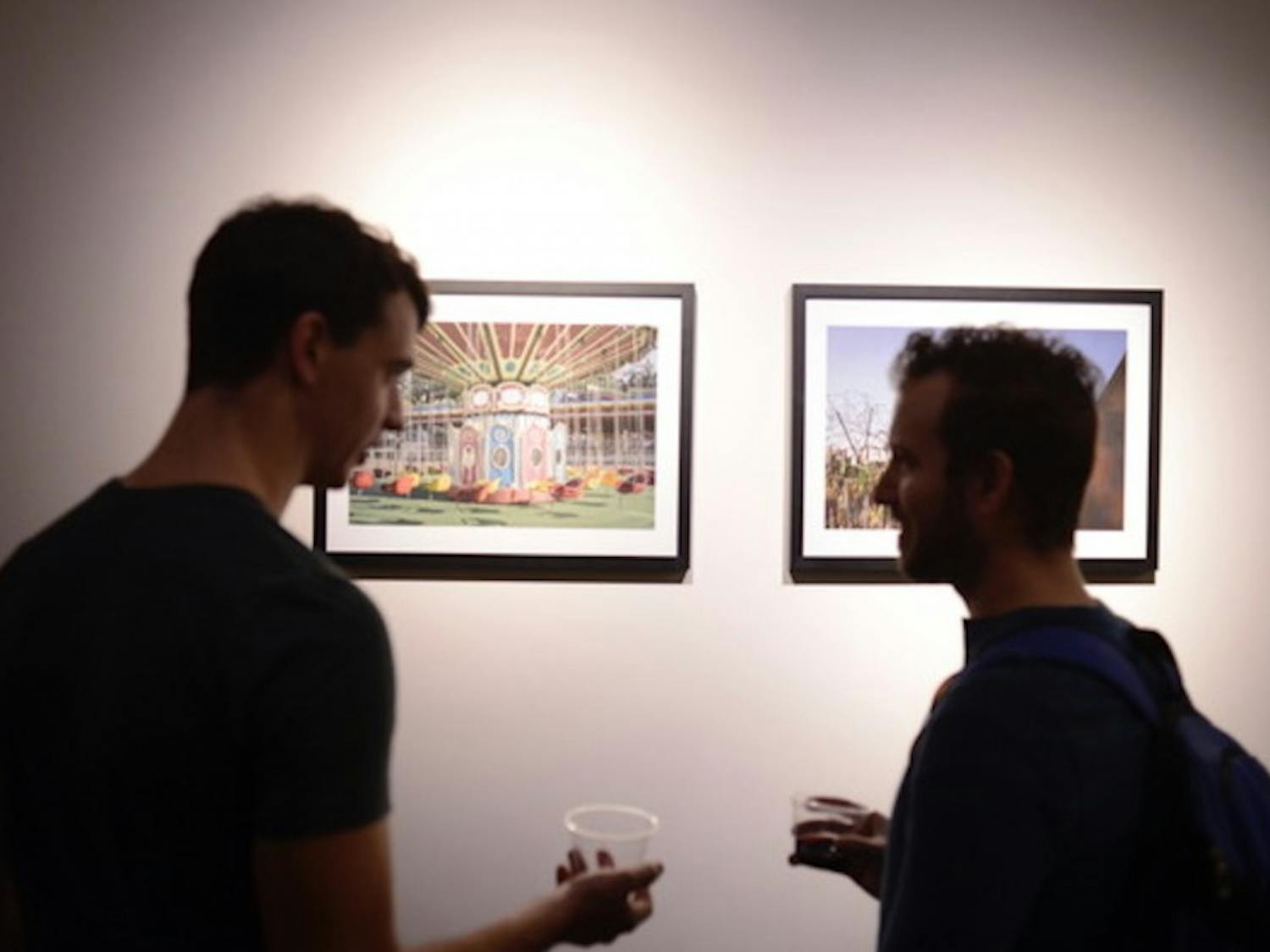 Two visitors chat at the opening reception for "Looking North" last Friday.