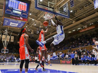 Mark Mitchell hangs on the rim after a dunk against Syracuse.