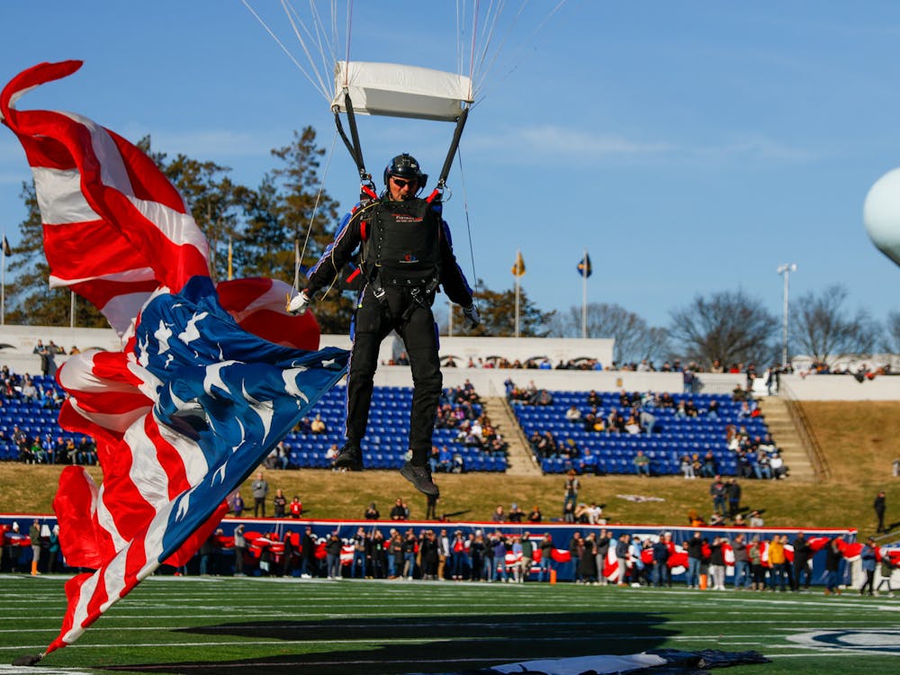A Team Fastrax jumper lands in Navy-Marine Corps Memorial Stadium before kickoff with the American flag flowing behind him. 