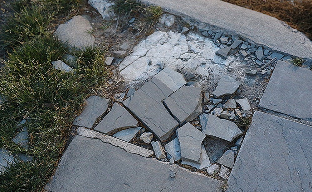 <p>Students have posted on Fix My Campus about loose tiles on walkways across campus in places like the West Campus bus stop (above) and French Family Science Center.</p>