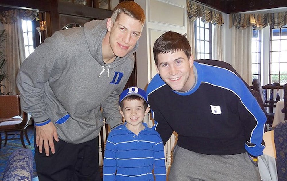 Nine-year-old Max Bonnstetter poses with men’s basketball players Mason Plumlee and and Todd Zafirovski.  Bonnstetter collects donations for music therapy program the Monday Life.